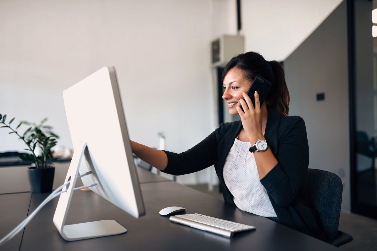 Titolare di una PMI che discute con un consulente esterno davanti a documenti contabili e un computer